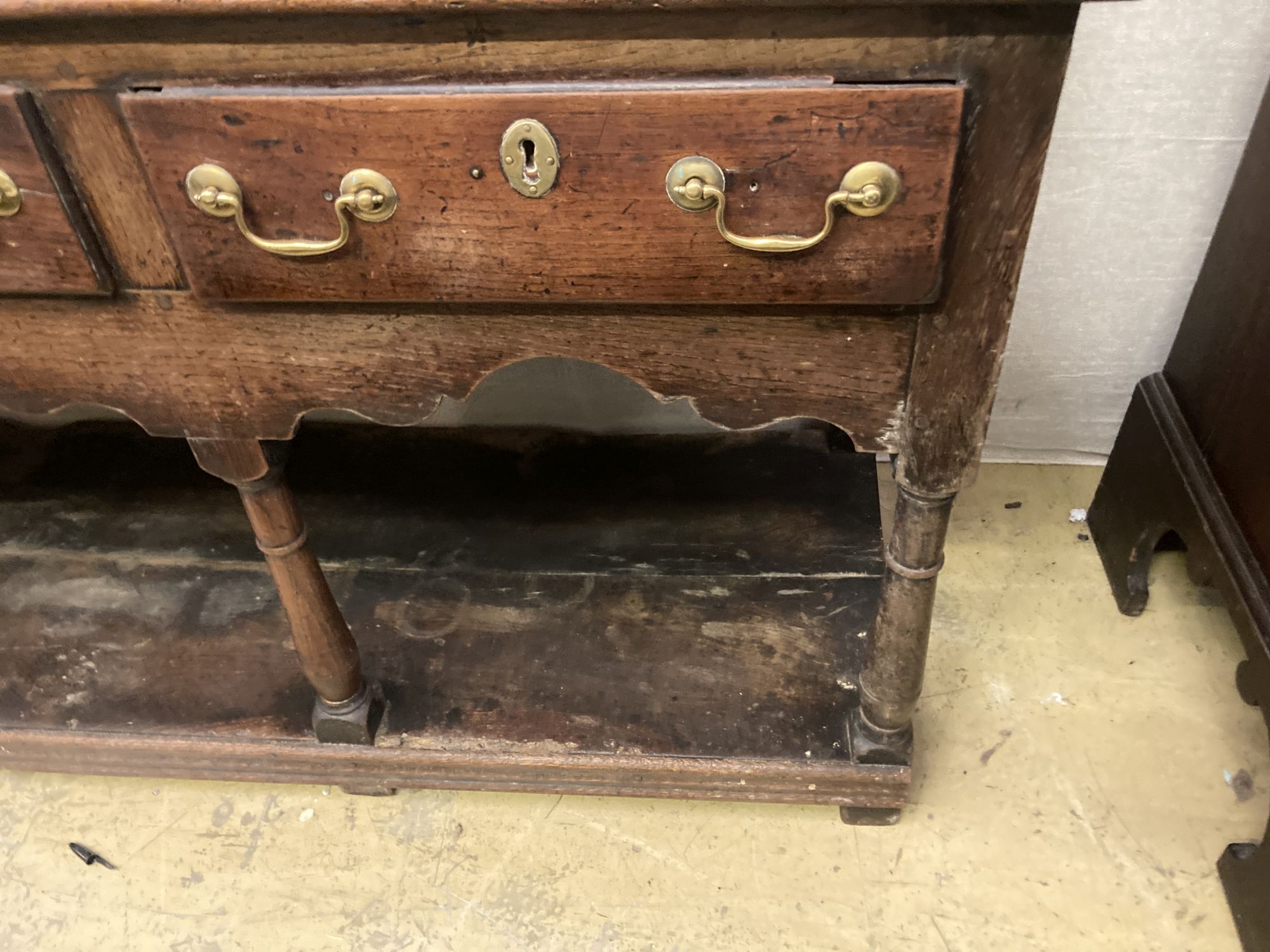 An 18th century oak potboard low dresser with associated rack, length 152cm, depth 48cm, height 193cm